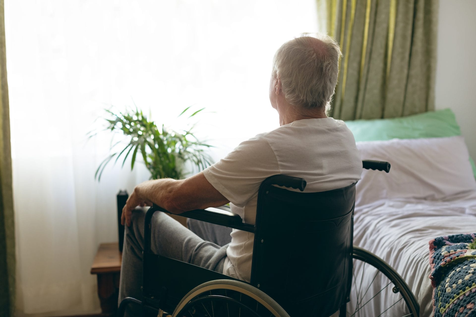 Senior Male Patient Looking Outside The Window of nursing home, elder law