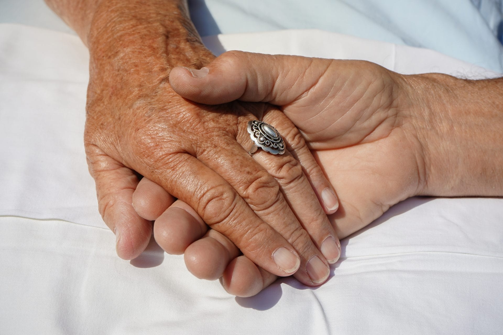 Elderly husband and wife holding hands, discussing power of attorney in tn